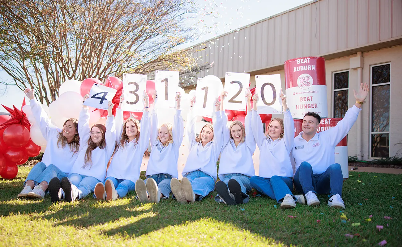 UA students hold up numbers to reveal the 2024 Beat Auburn Beat Hunger results: 431,120 pounds of food.