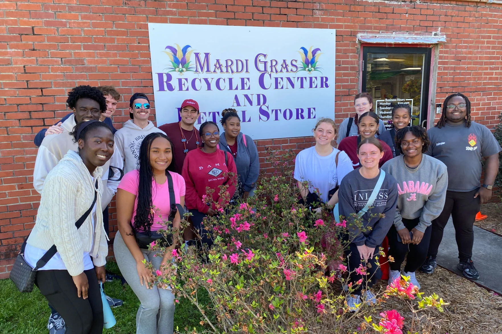 Group of students stand together outside in front of a 